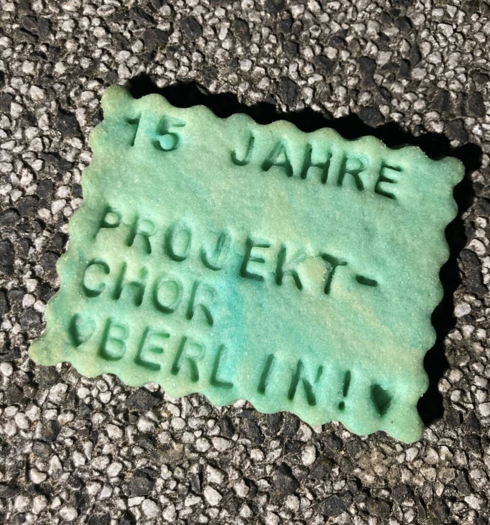 türkisfarbener Keks mit der Aufschrift "15 Jahre Projektchor Berlin"