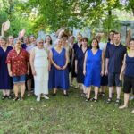 Gruppenfoto im Freien, aufgenommen vor dem ersten Konzert, alle sehr hochsommerlich gekleidet